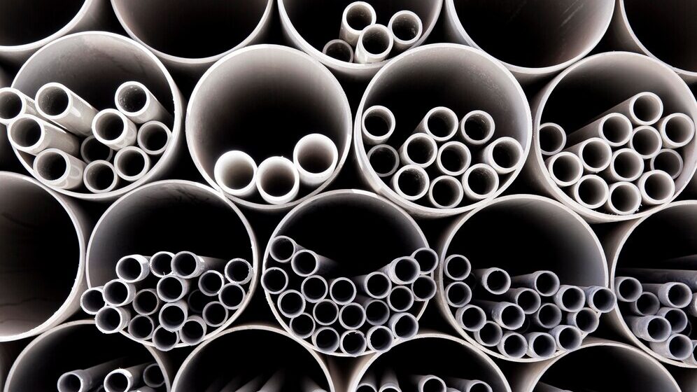 Organized bundles of PVC pipes used for plumbing and industrial applications.